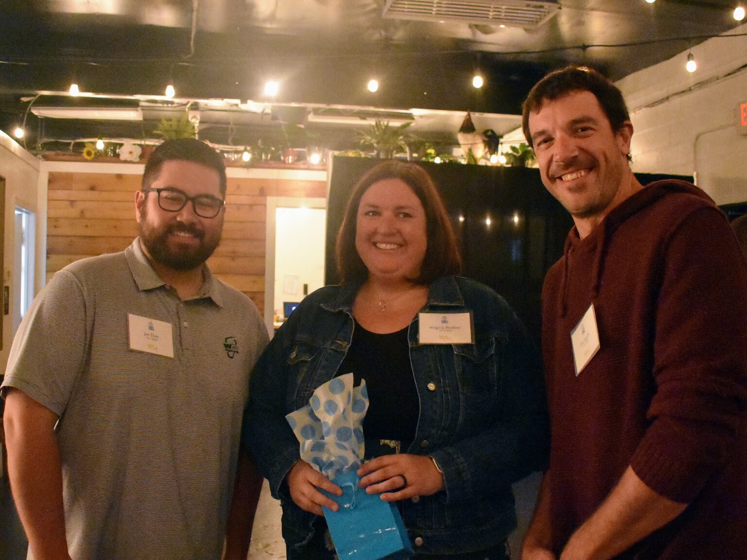Three people standing together after accepting an award