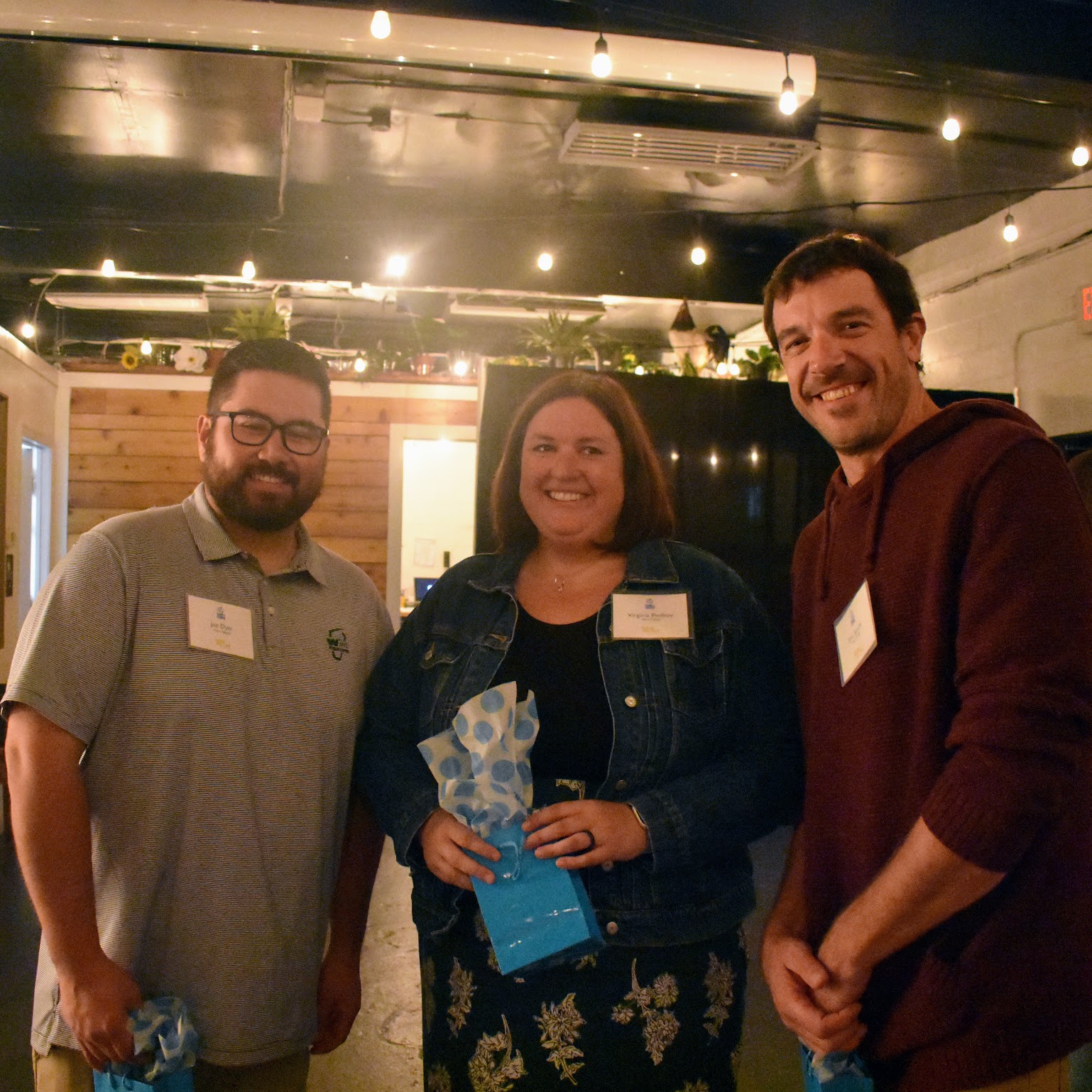Three people standing together after accepting an award
