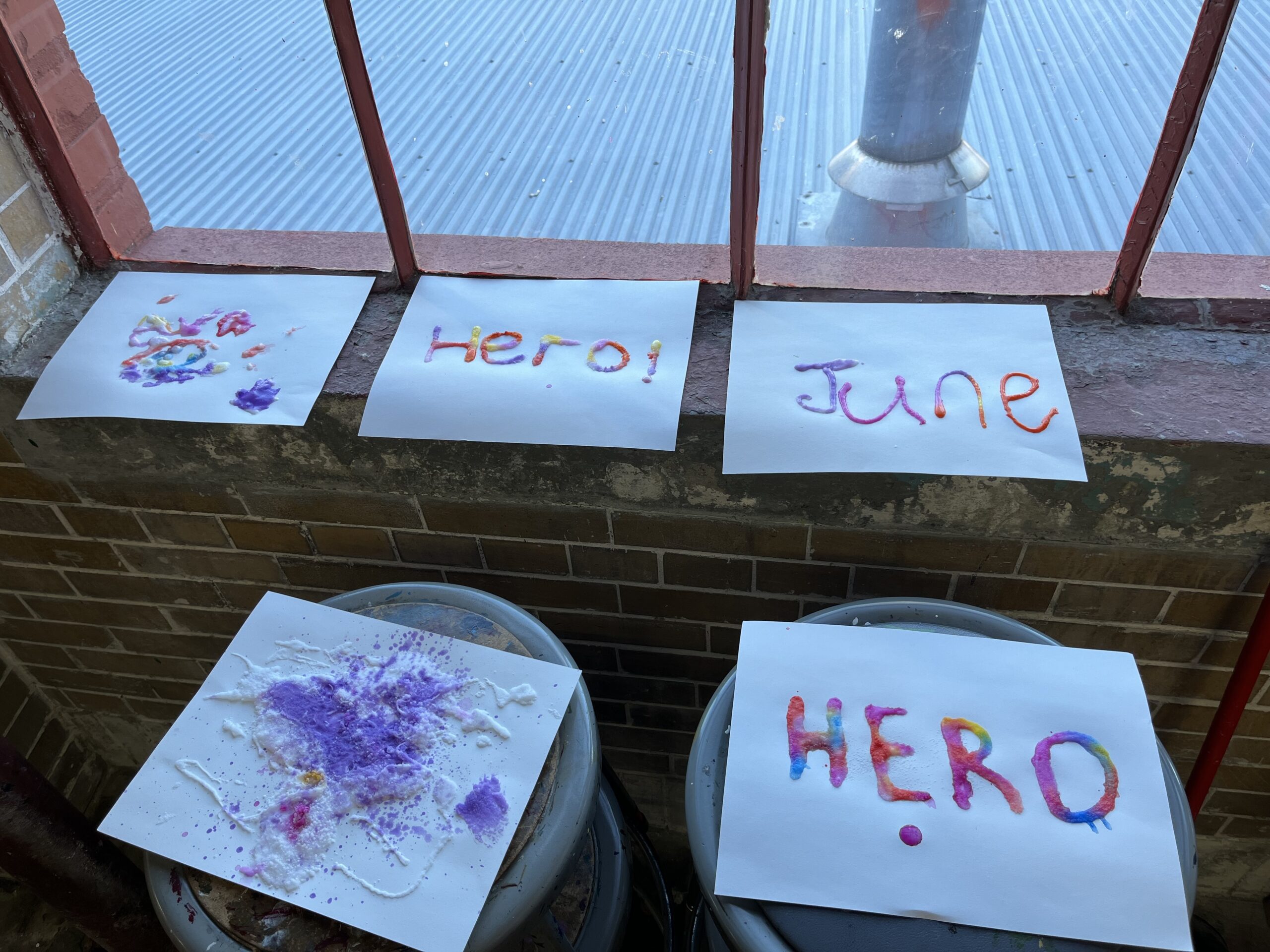 A row of paintings with the words hero and june at Connor's Heroes Art Session