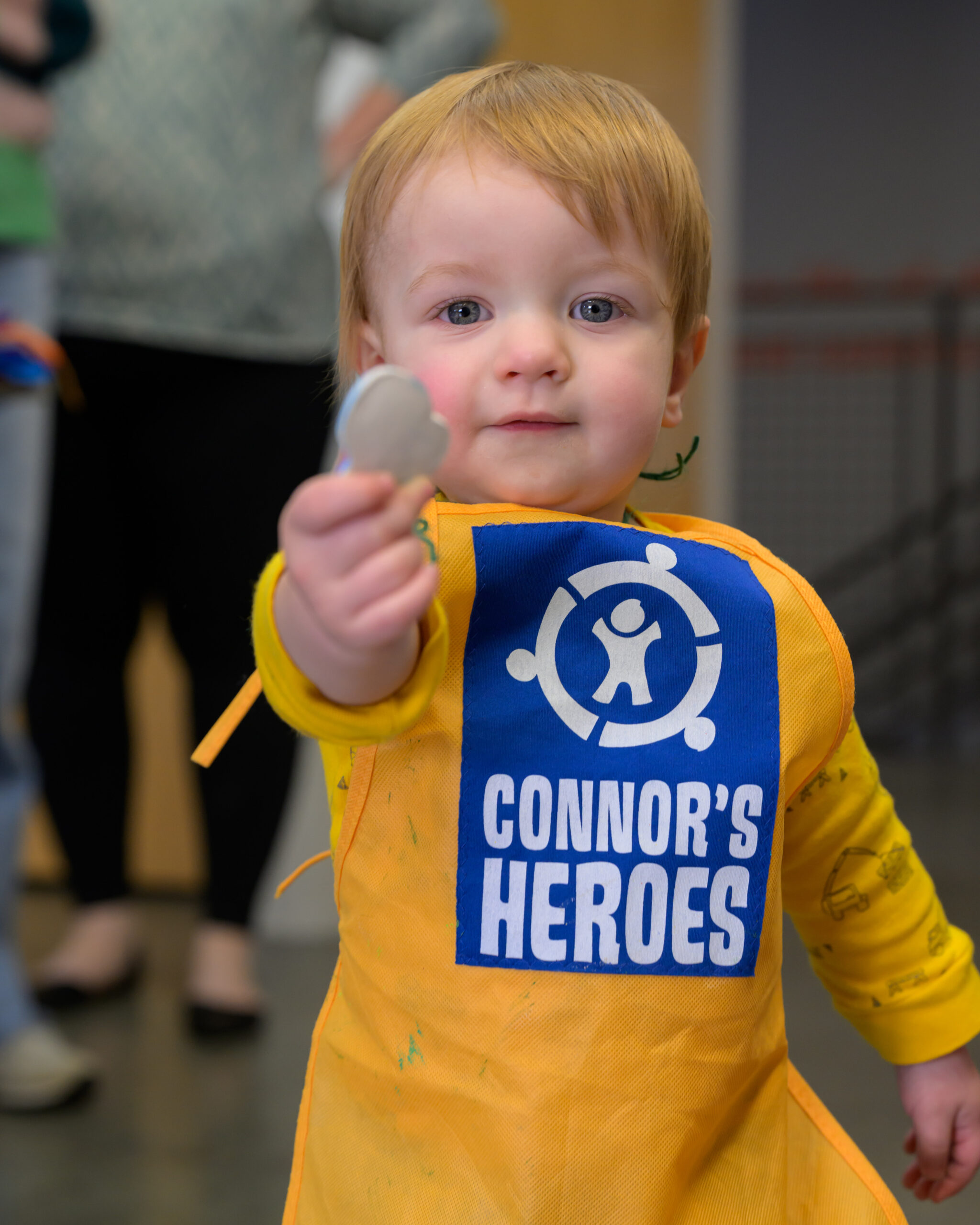 A toddler holds up a toy