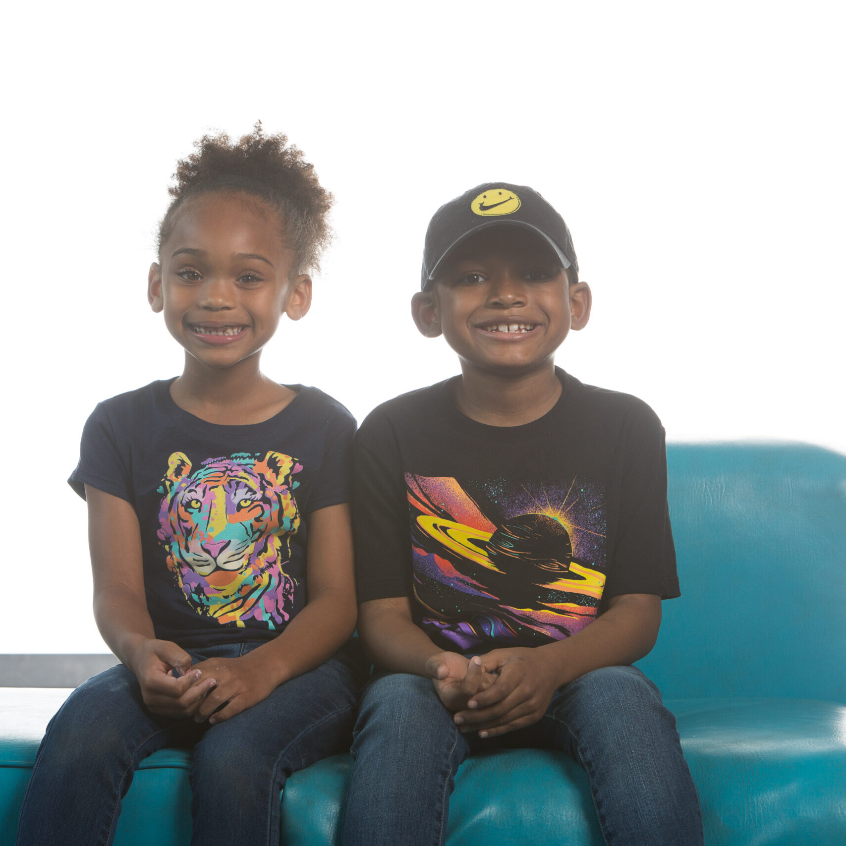 Aschemund and his sister sitting on a blue couch