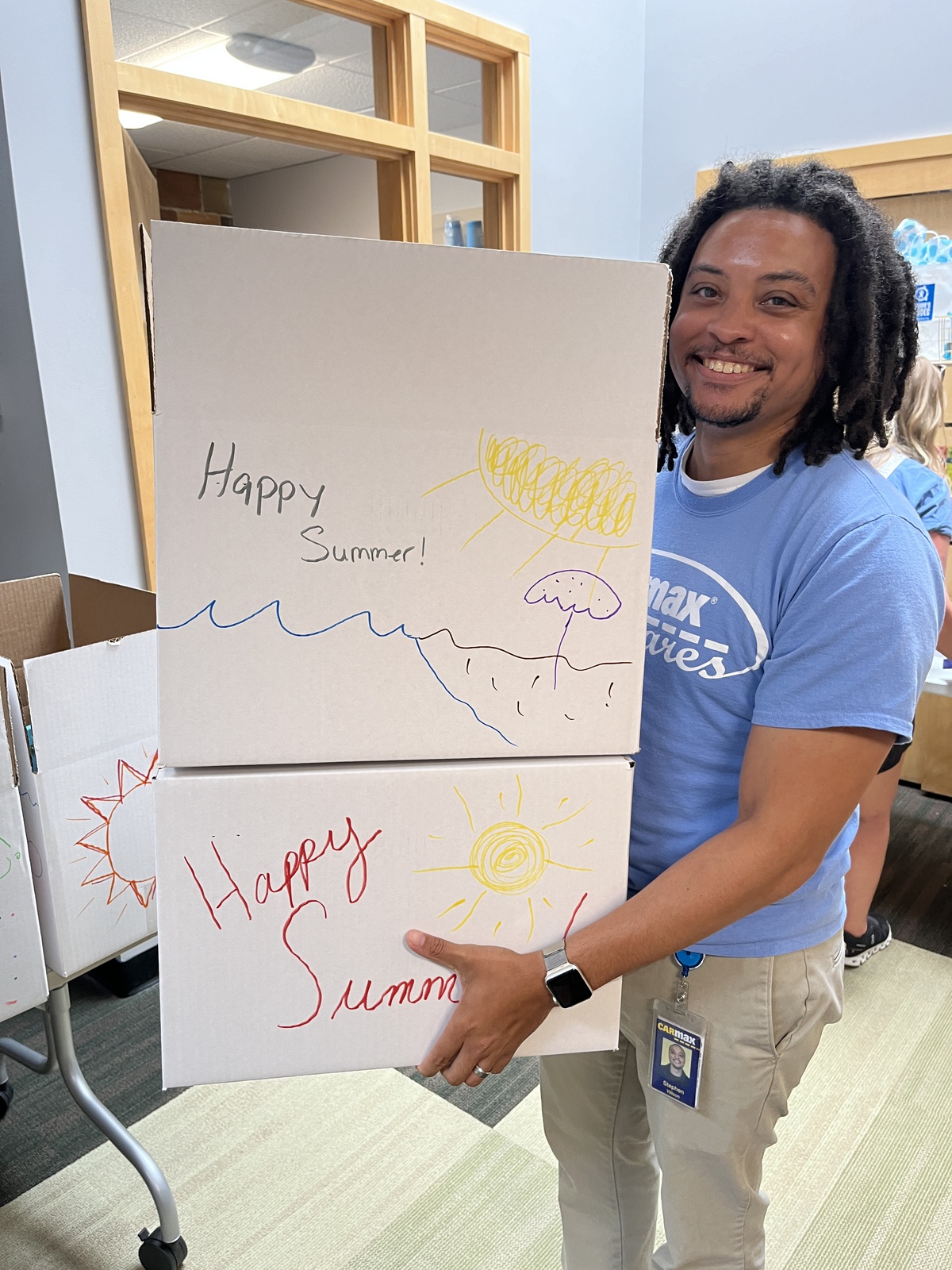 Man is carrying two boxes decorated with words Happy Summer