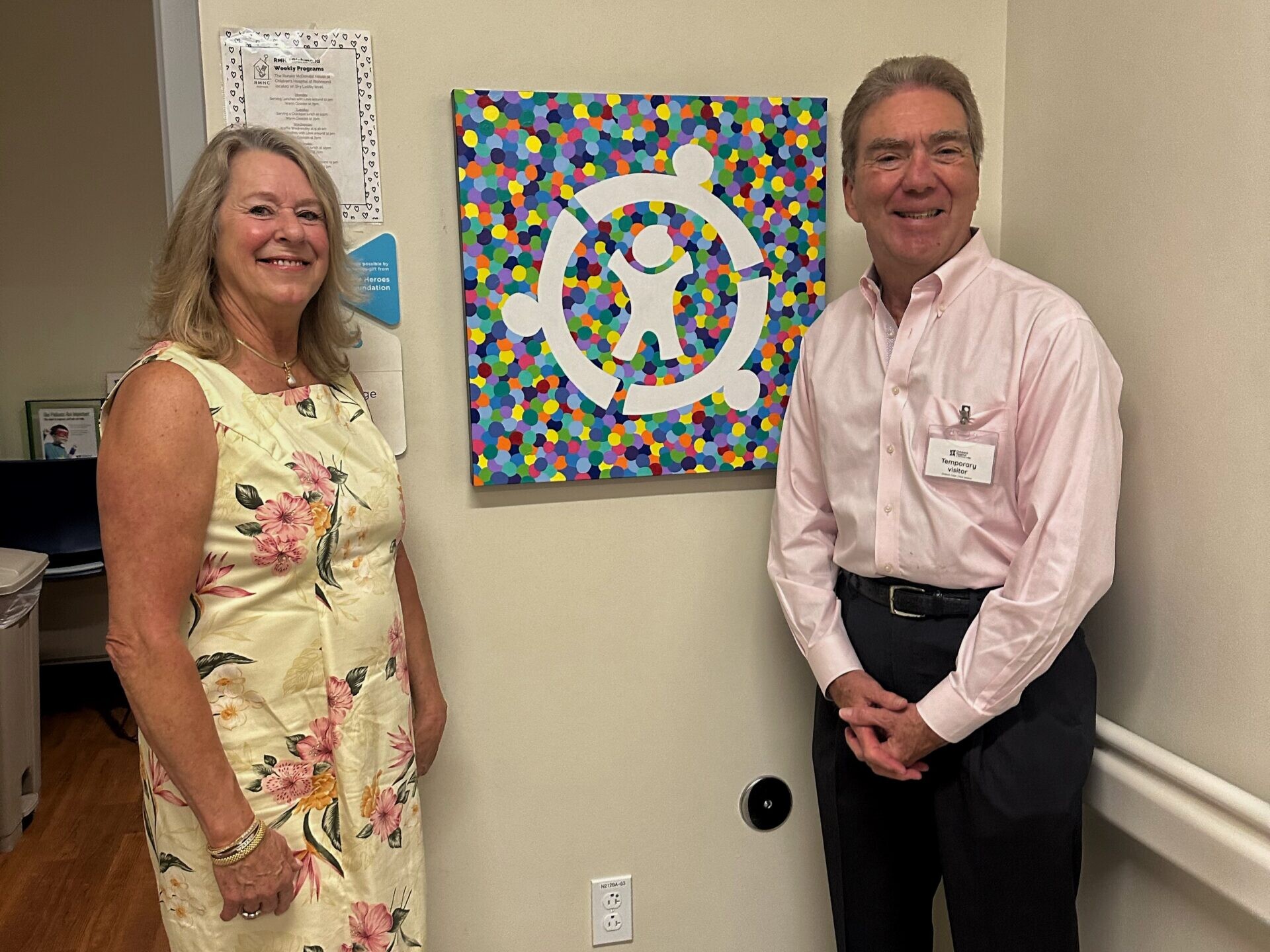 Ted and Mary are standing next to their painting