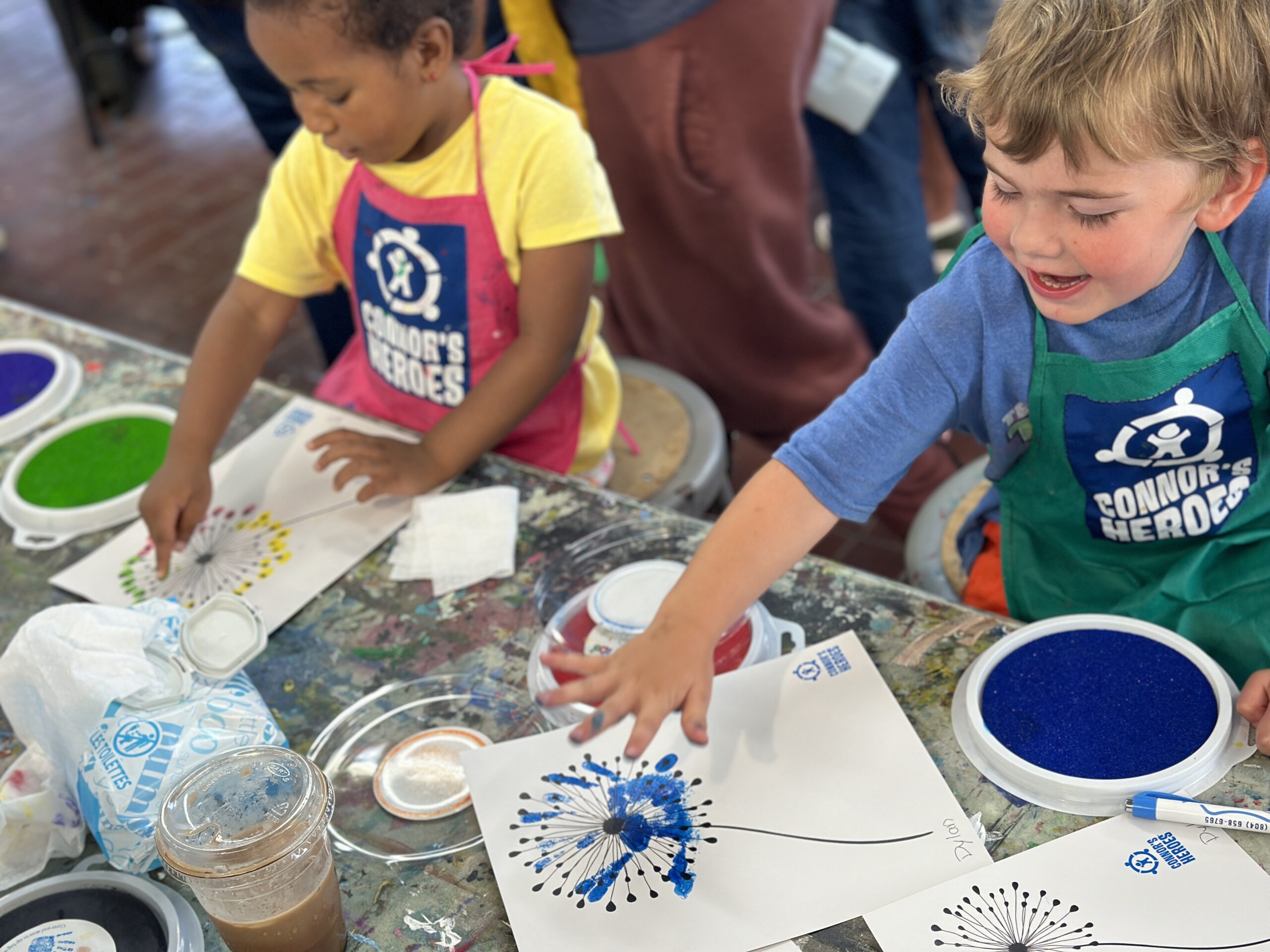 Two kids paint with their fingerprints