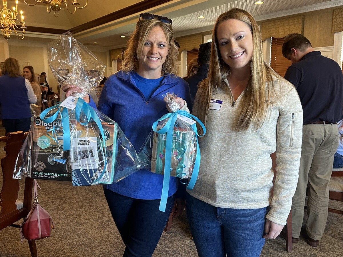 Employees hold up their gift bags for Connor's Heroes