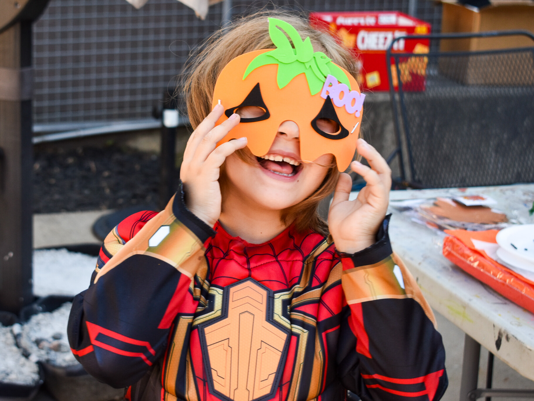 A child is wearing a pumpkin halloween mask