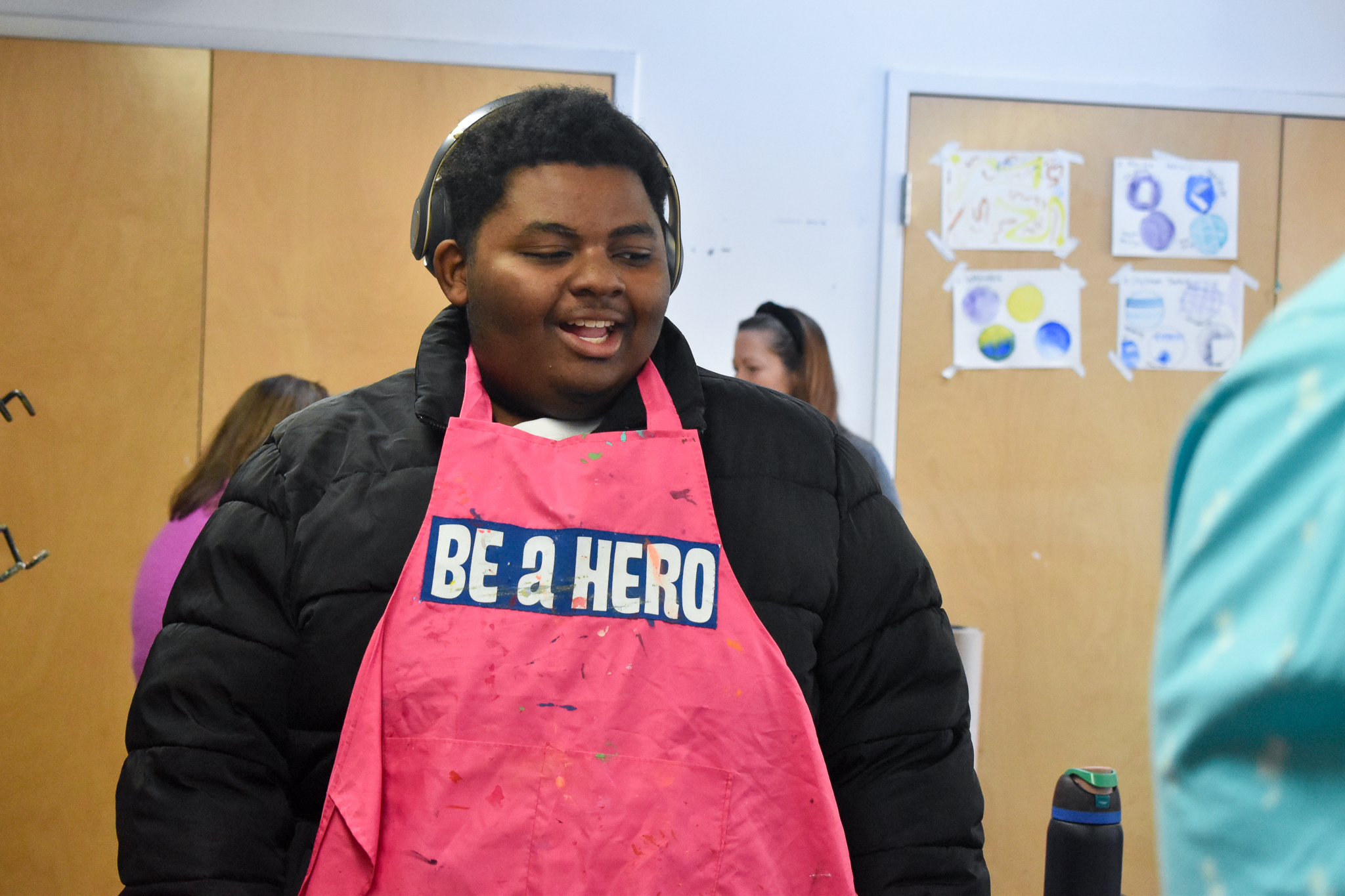 A teen is at a heroes art session