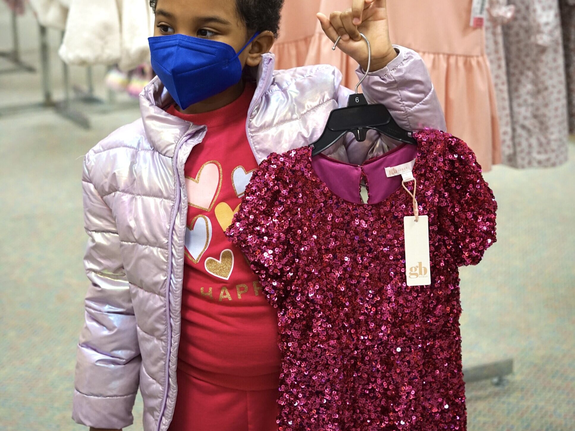 Journey holds up a red gown