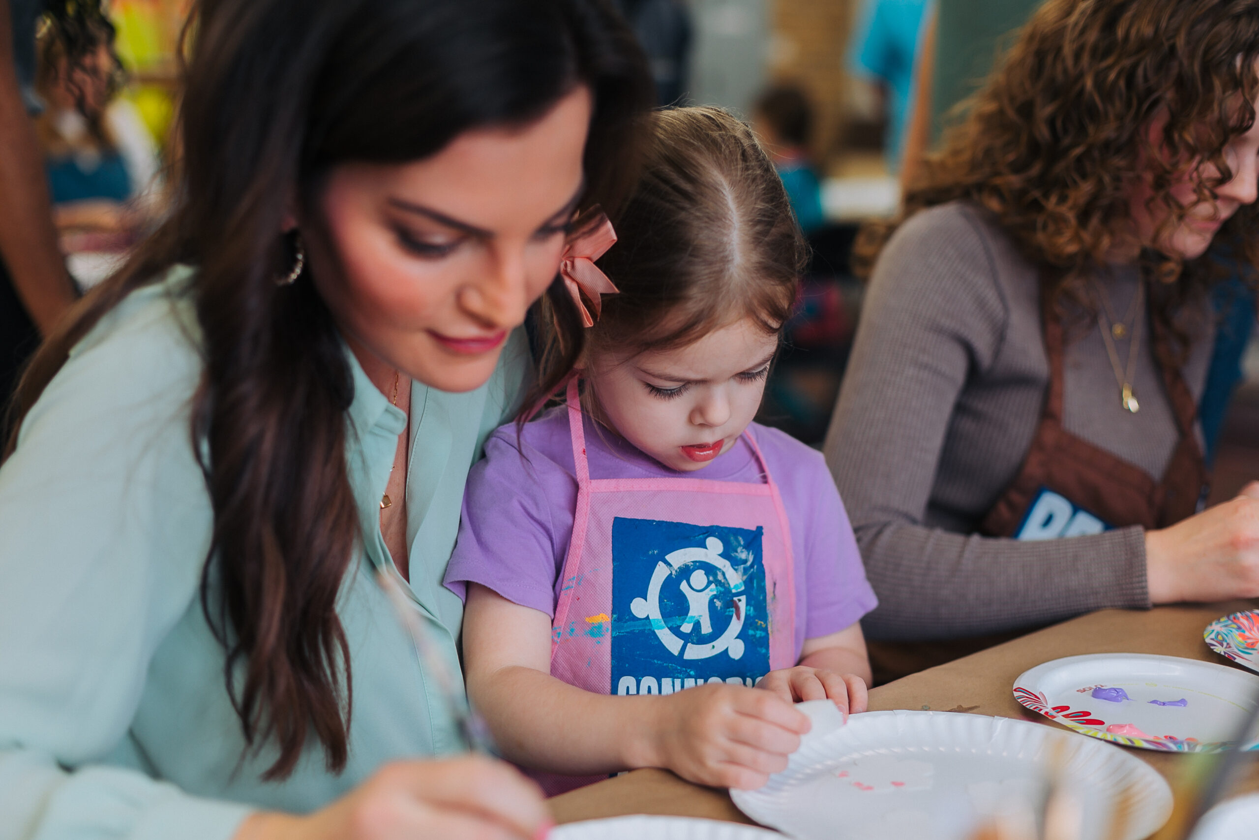 parent helping her child with a craft