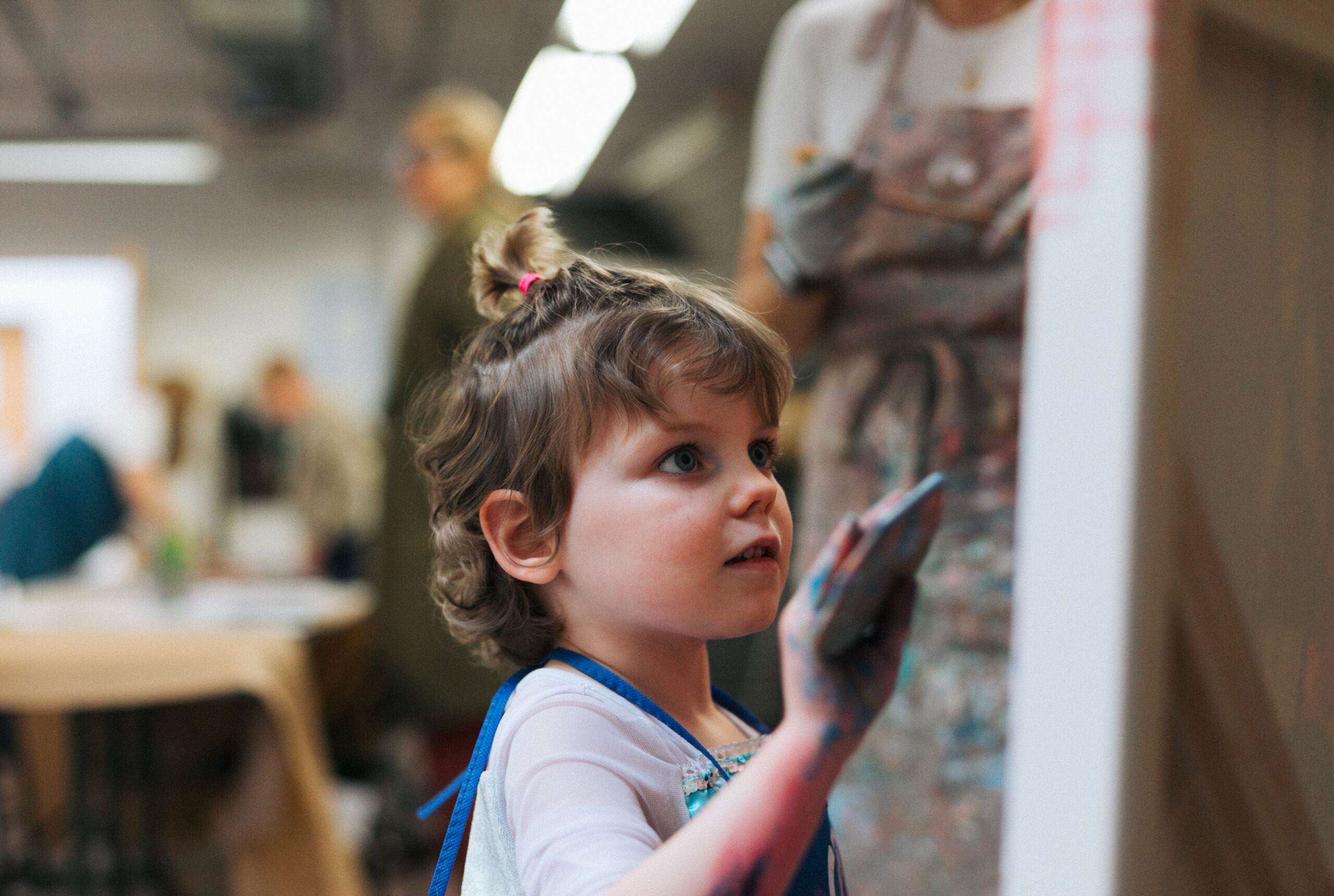 A child is painting a large painting