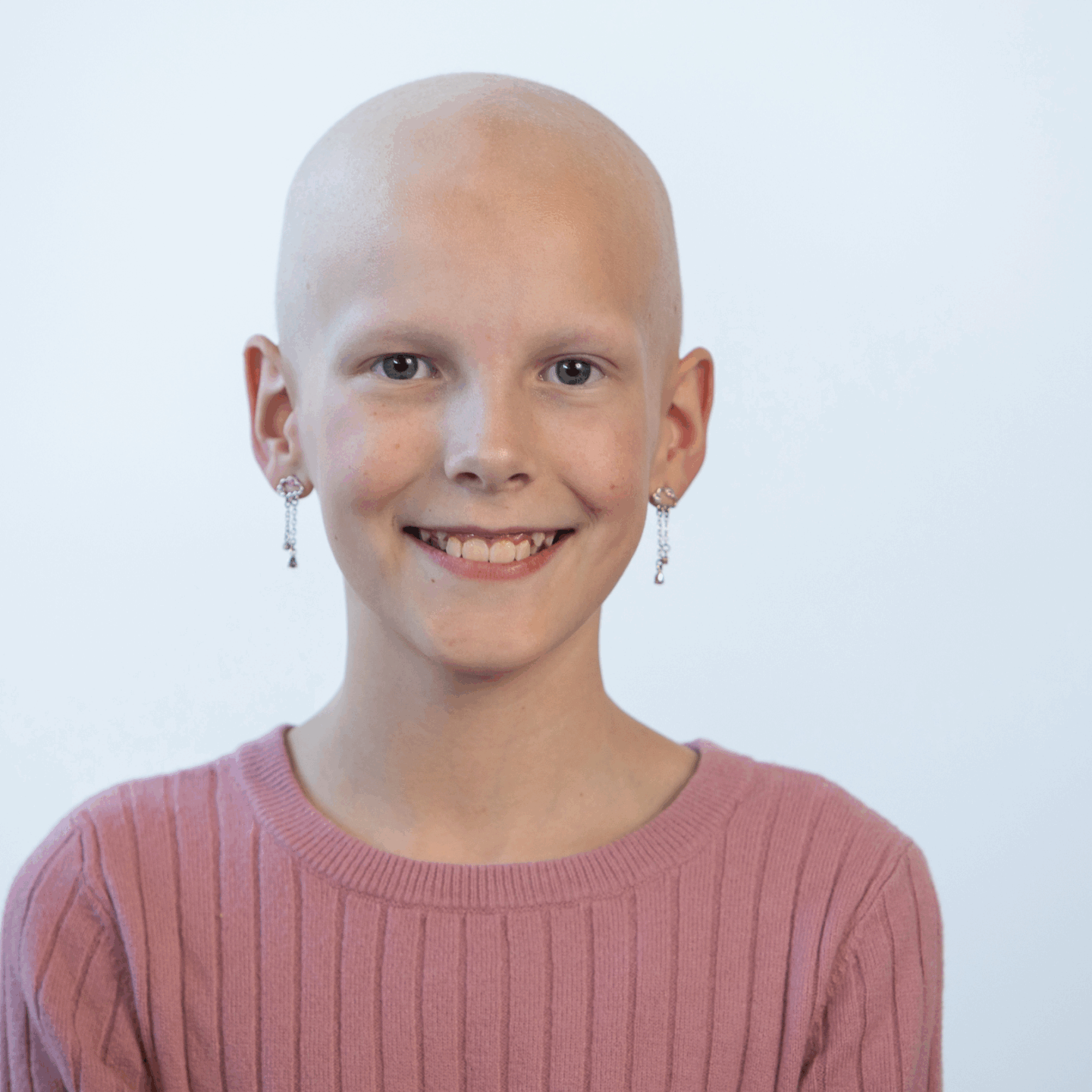 A girl with cancer poses for a photo