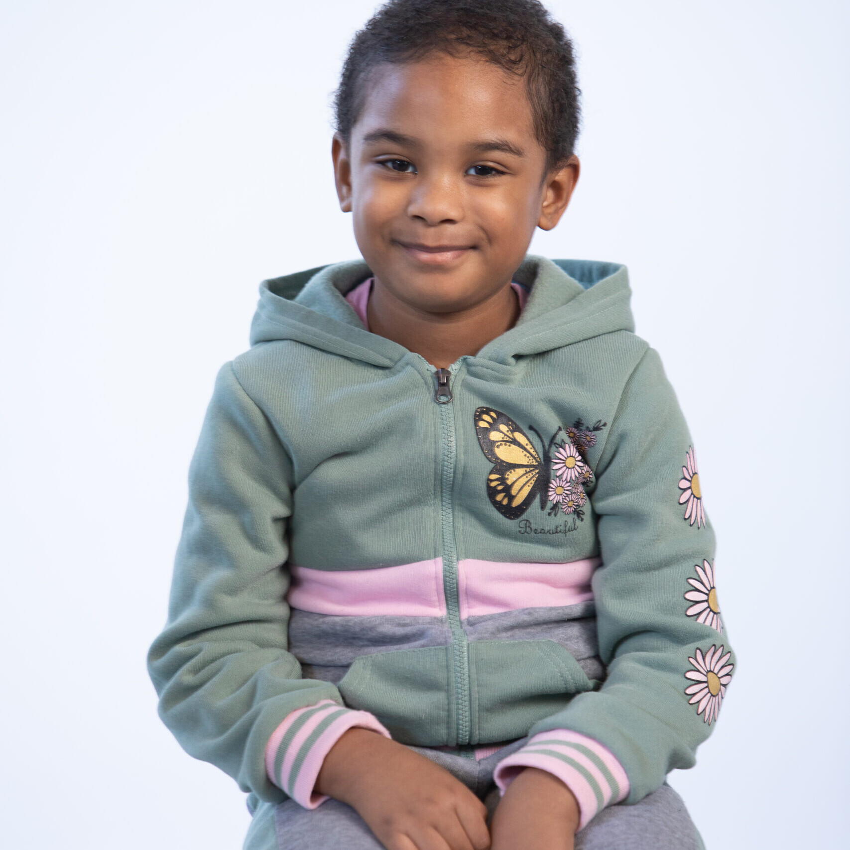 a child with cancer poses for a phot