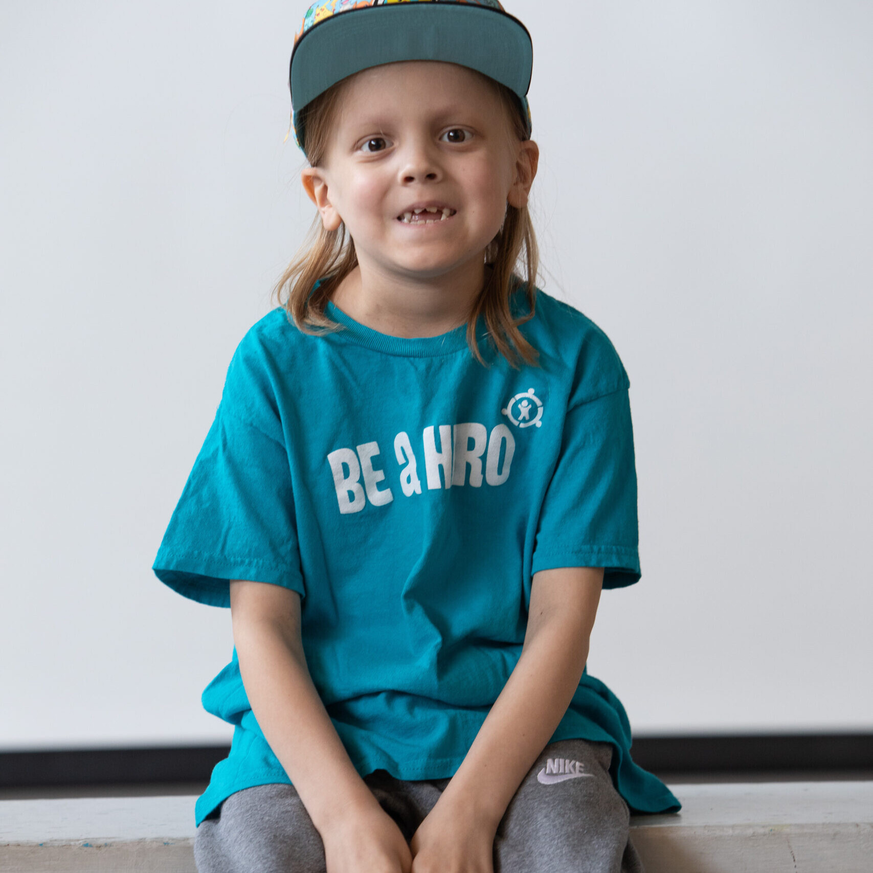 A child with cancer poses for a photo