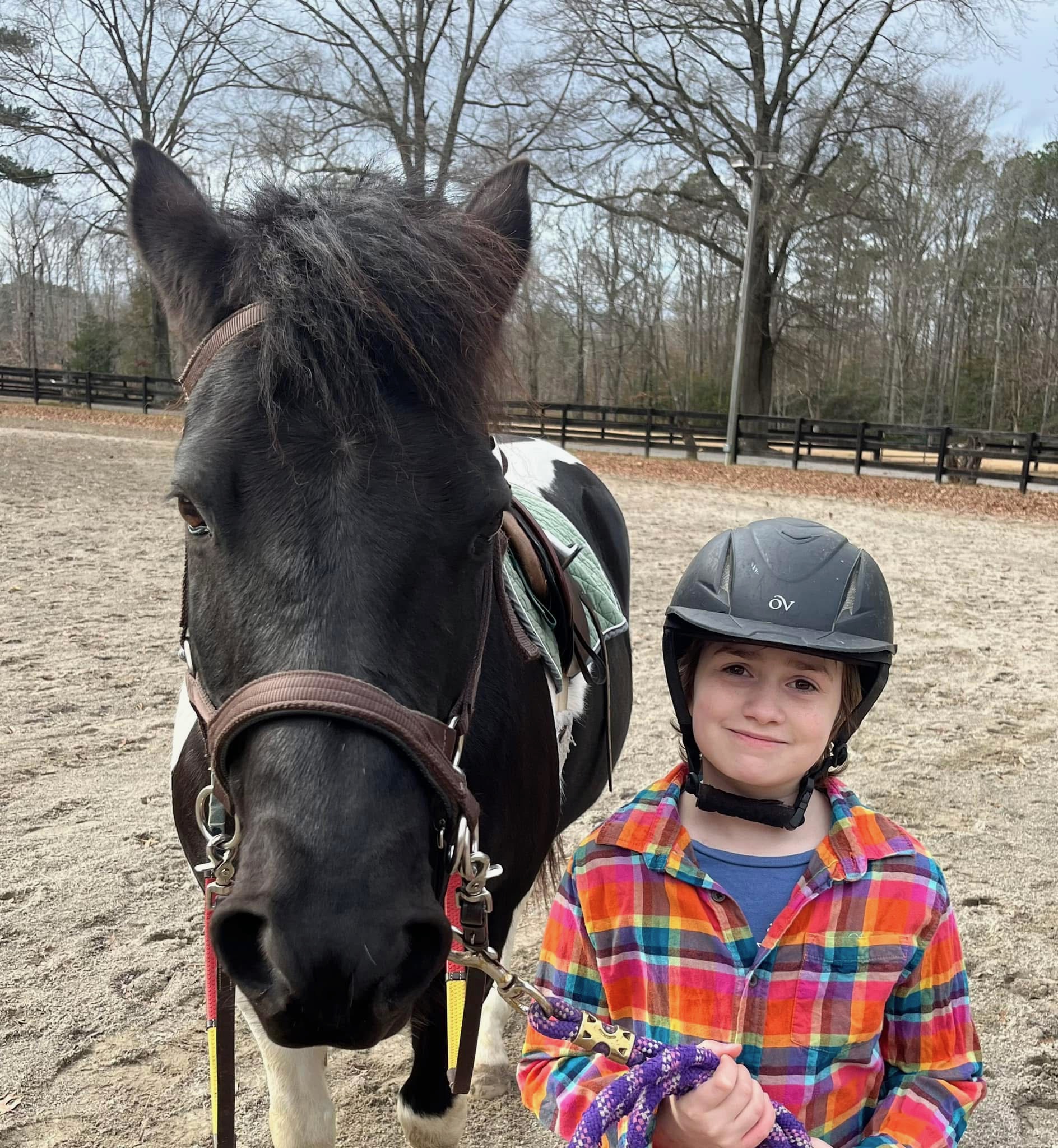 A girl is standing next to a horse