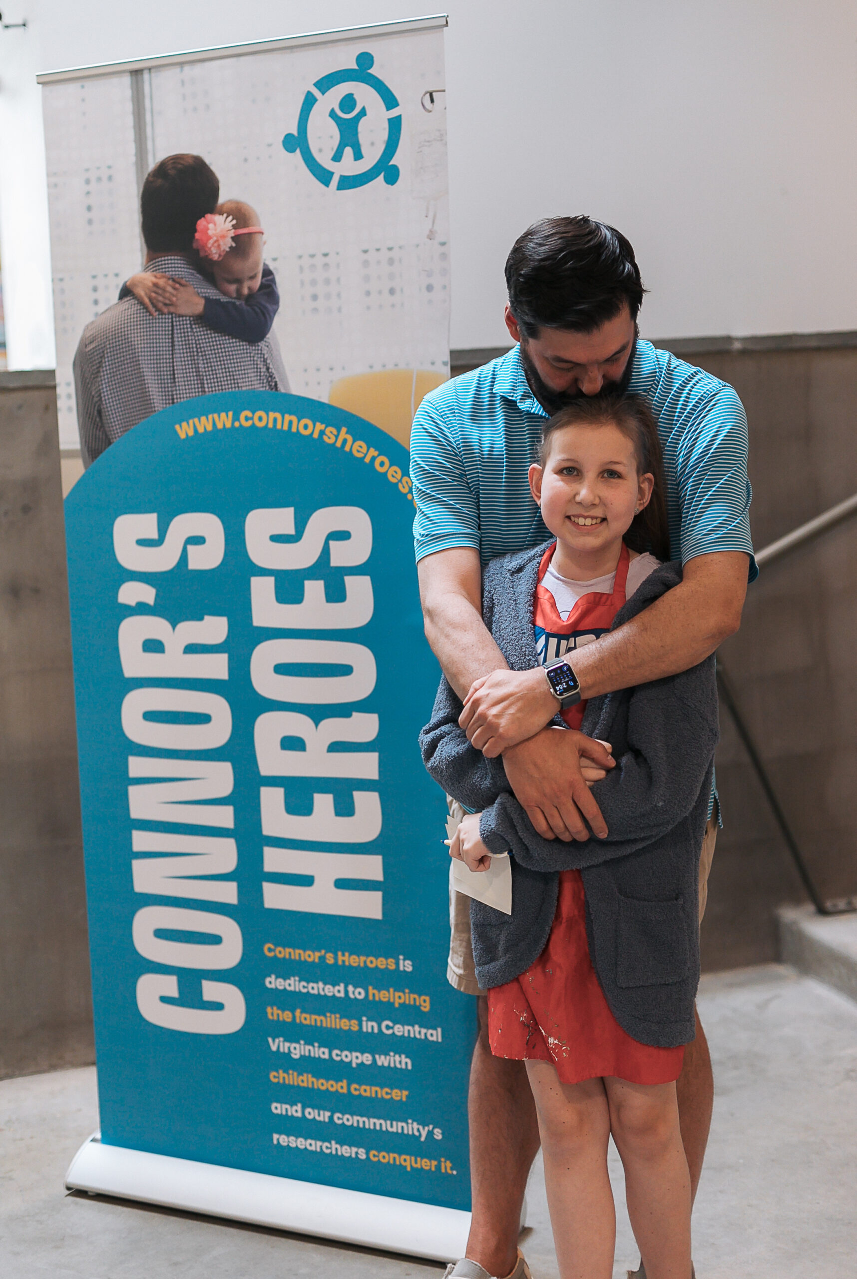 A girl stands next to a banner with her photo