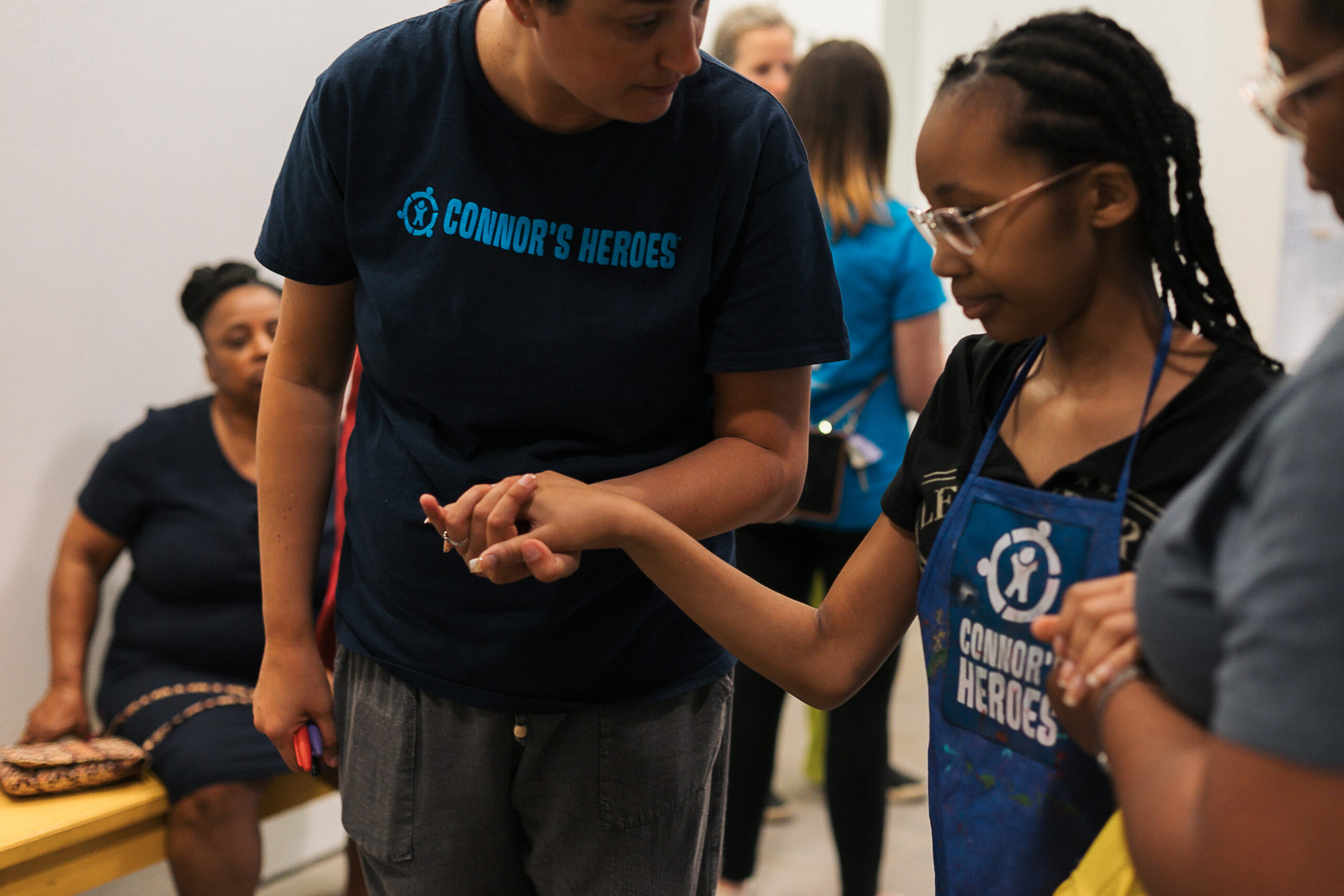 A women is holding the hand of a teen