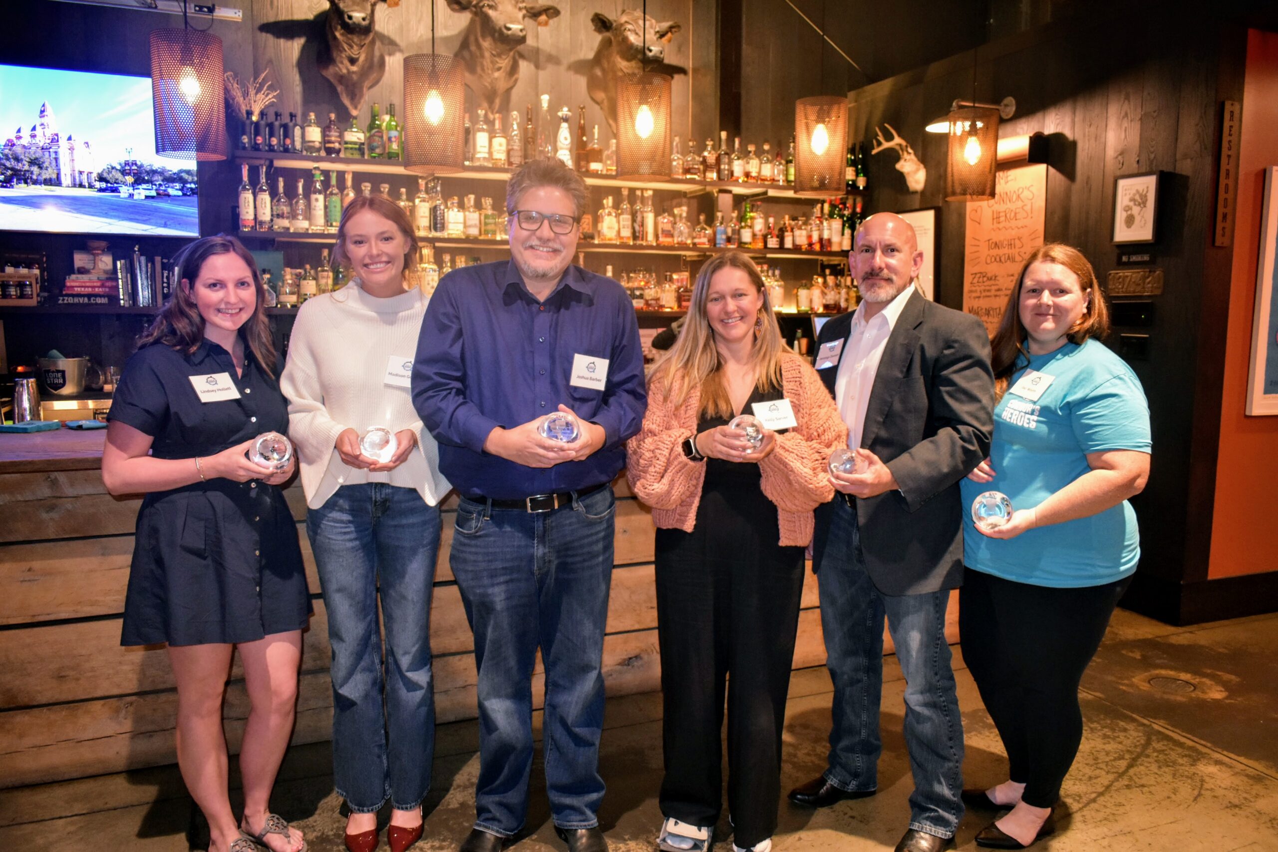 a group of six people pose with their awards