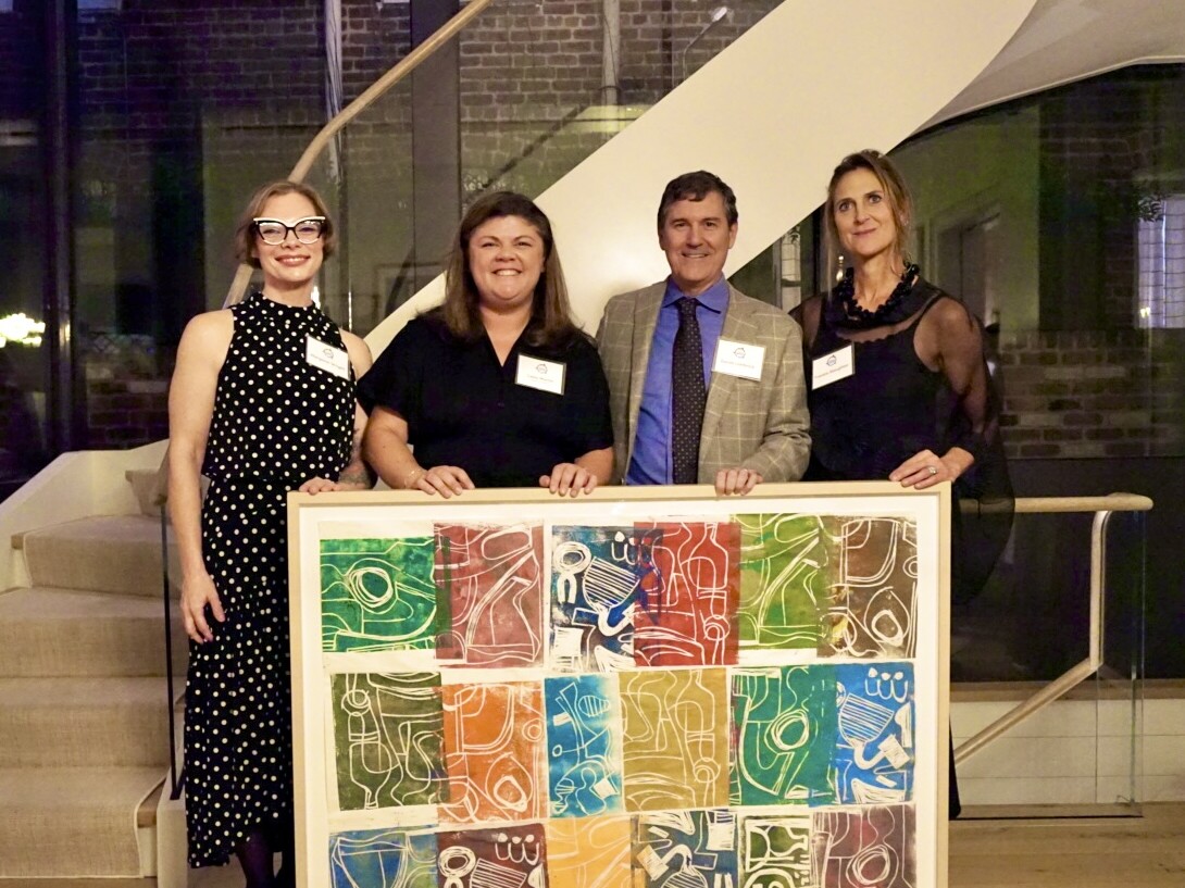 four people with a painting