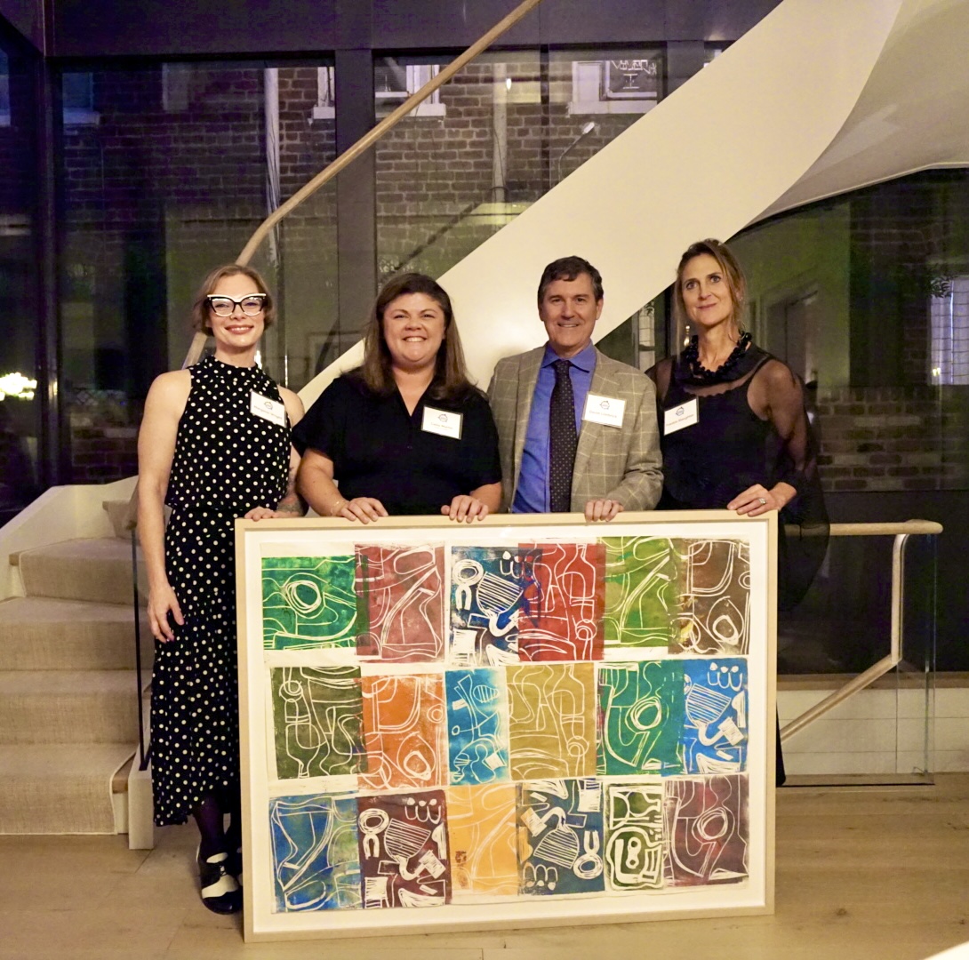 four people with a painting